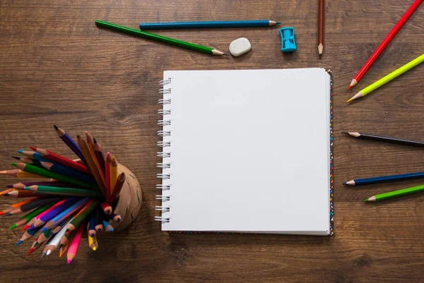 Blanco papier en kleurrijke potloden op de houten tafel. Bovenaanzicht — Stockfoto