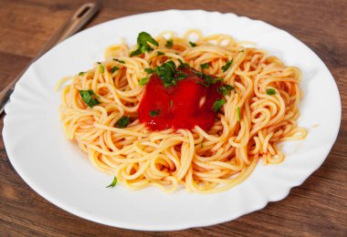 Beyaz tabakta domates soslu makarna spagetti. ahşap bir arka plan üzerinde.
