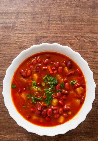 Zeleninová polévka s červenou fazolí, rajčat na dřevěné pozadí. s prostorem kopie. pohled shora — Stock fotografie