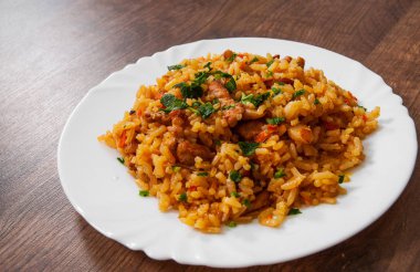 Pirinç sebze ve et ahşap masa üzerinde bir plaka ile.