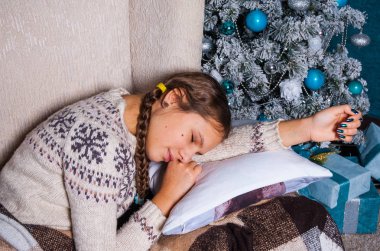 Noel ağacı arka plan üzerinde uyuyan kız