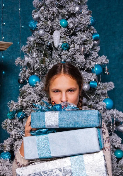 Teenager Mädchen halten Stapel von Weihnachtsgeschenken Geschenk-Box auf Tannenbaum Hintergrund — Stockfoto