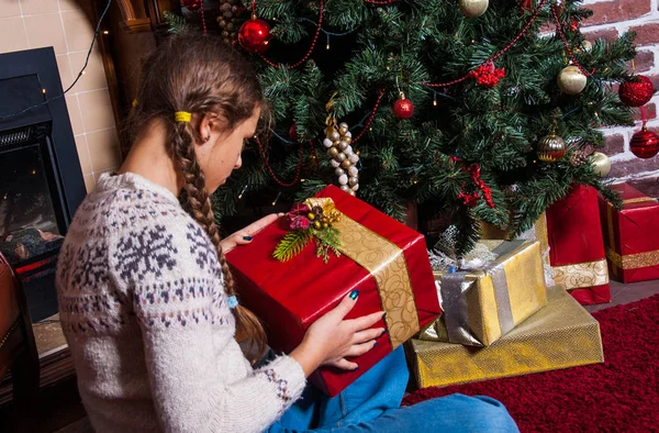 Teenager Mädchen halten Geschenke Geschenkbox auf Weihnachtsbaum Hintergrund — Stockfoto