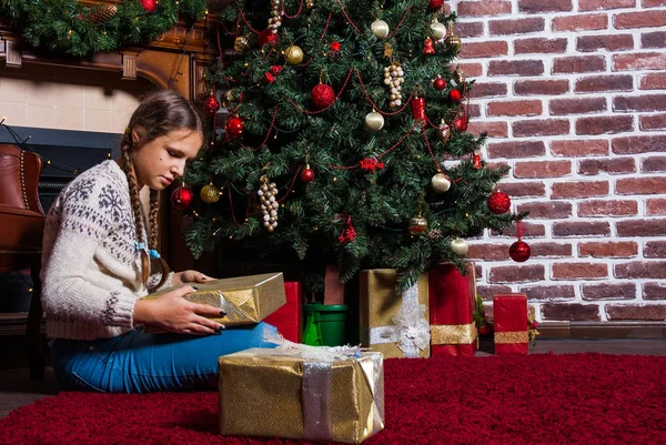 Teenager Mädchen halten Geschenke Geschenkbox auf Weihnachtsbaum Hintergrund — Stockfoto