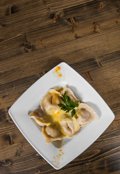 Las albóndigas de carne - los pelmeni rusos, los ravioles con la carne sobre el fondo de madera. con espacio para copias. vista superior — Foto de Stock