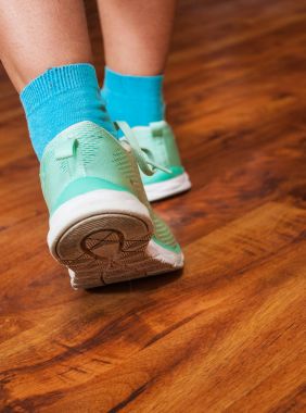 Sole koşu ayakkabısı. Snickers ile kadın ayak kapatın. bir ahşap zemin arka planı