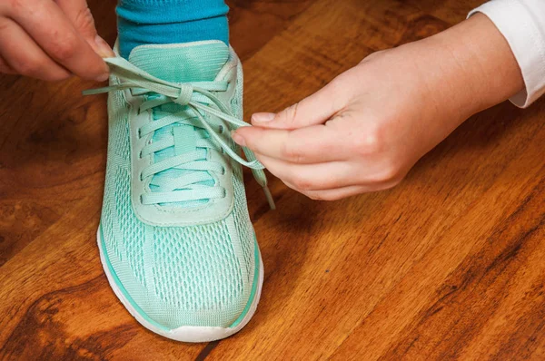 Manos Una Mujer Joven Con Cordones Zapatillas Verdes Contra Fondo — Foto de Stock