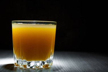 Bardak taze portakal suyu kopya alanı koyu siyah zemin üzerine basıldığında.