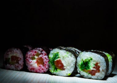 Lezzetli suşi koyu arka plan üzerine alır. Japon geleneksel yemekleri. kopya alanı ile.