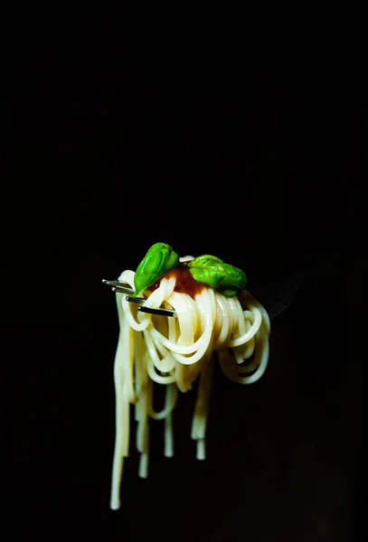 コピー スペースと暗い背景の木のフォークにバジルとトマトのスパゲティ — ストック写真
