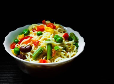 Kase üzerinde koyu ahşap arka plan kopya alanı ile karışık sebze ile anlık erişte.