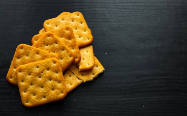 Koyu ahşap arka plan üzerinde kuru tuzlu kraker kare