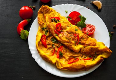 omlet koyu ahşap zemin üzerine bir tabak içinde