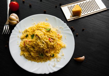 koyu ahşap zemin üzerine krem peynir soslu spagetti makarna