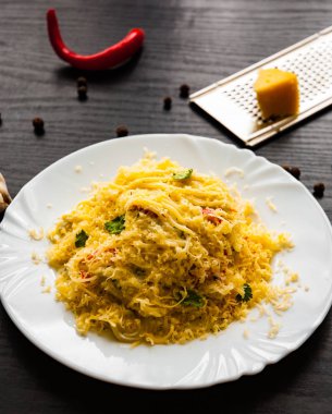 koyu ahşap zemin üzerine krem peynir soslu spagetti makarna