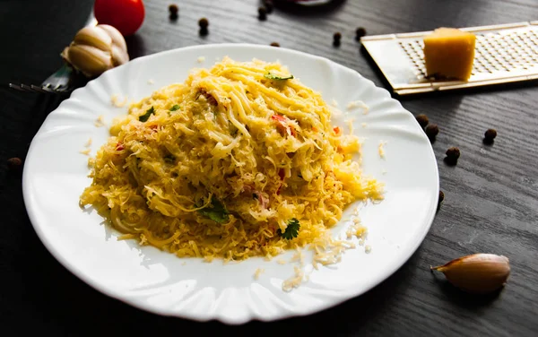 spaghetti pasta with cream cheese sauce on a dark wooden background