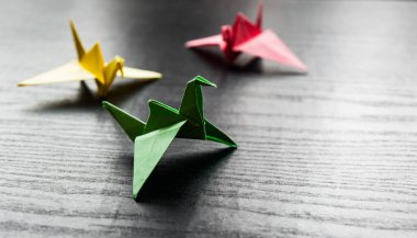Kopya alanı ile darkwooden arka plan üzerinde renkli origami bir grup vinç