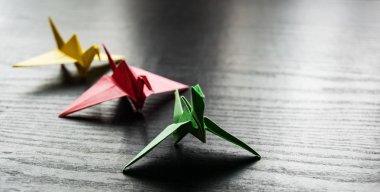 Kopya alanı ile darkwooden arka plan üzerinde renkli origami bir grup vinç