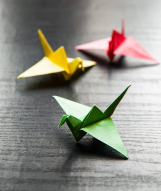Kopya alanı ile darkwooden arka plan üzerinde renkli origami bir grup vinç