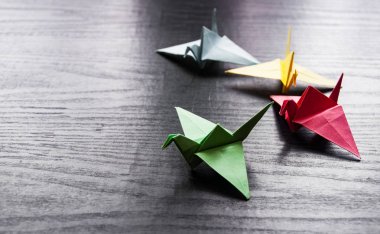Kopya alanı ile darkwooden arka plan üzerinde renkli origami bir grup vinç