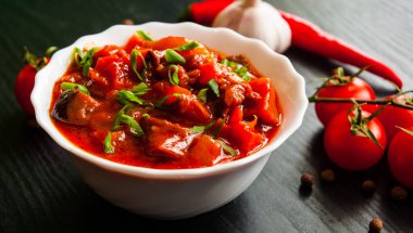 Gulaş. Patlıcan, biber, domates ve koyu ahşap arka plan üzerinde beyaz kapta havuç ile sebze rague