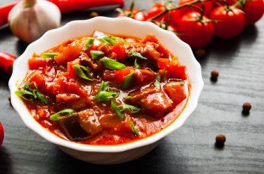 Gulaş. Patlıcan, biber, domates ve koyu ahşap arka plan üzerinde beyaz kapta havuç ile sebze rague