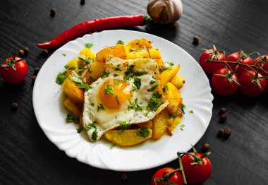 kızarmış yumurta koyu ahşap zemin üzerine bir tabak patates ile