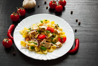 tavuk ve koyu ahşap arka plan tabakta sebze Farfalle makarna salatası