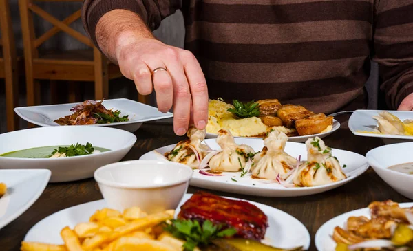 Man Hand Takes Khinkali Plate — стоковое фото