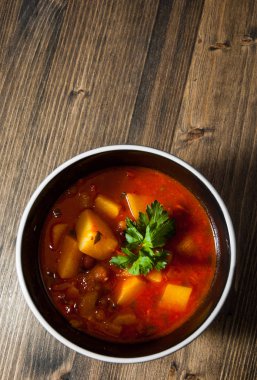 Ahşap masa üzerinde seramik kase sebze ve fasulye çorbası