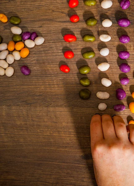 Vrouw Hand Verzamelt Zelfs Rij Van Kleurrijke Snoepjes Een Houten — Stockfoto