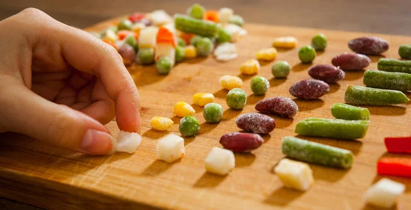 Woman Hand Collects Even Row Colorful Frozen Mixed Vegetables Wooden — Stock Photo, Image