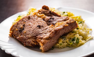 eti fileto ahşap masa bir tabakta sebze salatası ile