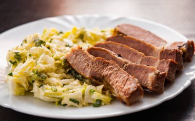 eti fileto ahşap masa bir tabakta sebze salatası ile