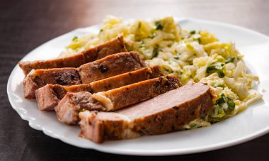 eti fileto ahşap masa bir tabakta sebze salatası ile