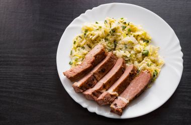 eti fileto ahşap masa bir tabakta sebze salatası ile