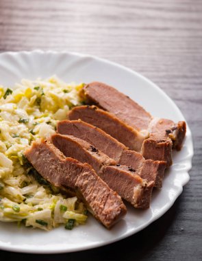 eti fileto ahşap masa bir tabakta sebze salatası ile