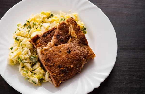 eti fileto ahşap masa bir tabakta sebze salatası ile