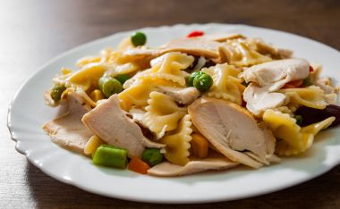 tavuk göğsü fileto ve ahşap arka plan tabakta sebze Farfalle makarna salatası