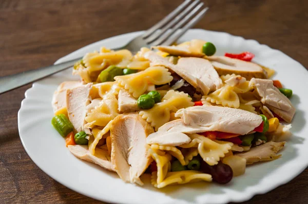 tavuk göğsü fileto ve ahşap arka plan tabakta sebze Farfalle makarna salatası