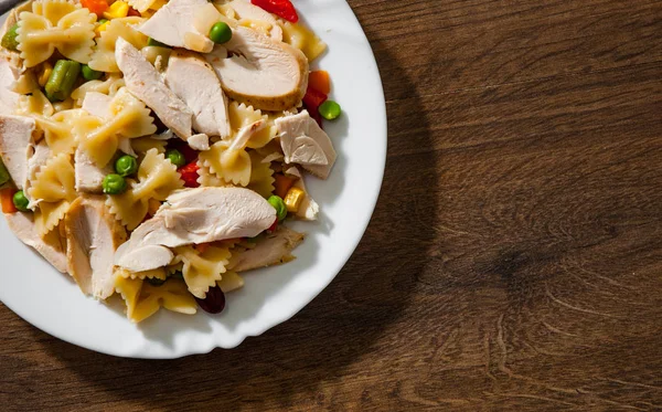 tavuk göğsü fileto ve ahşap arka plan tabakta sebze Farfalle makarna salatası