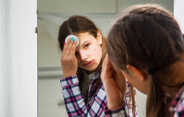 代の少女が鏡の前に彼女の顔に触れる — ストック写真