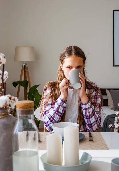 代の少女が朝食と自宅の台所で紅茶やコーヒーを飲む — ストック写真