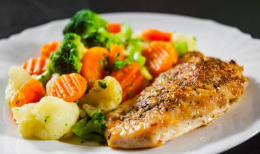 Karışık Sebzeli tavuk fileto. karnabahar, brokoli ve havuç ahşap arka plan üzerinde beyaz plaka.