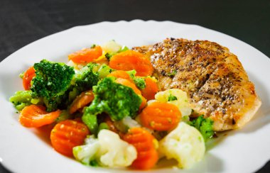 Karışık Sebzeli tavuk fileto. karnabahar, brokoli ve havuç ahşap arka plan üzerinde beyaz plaka.