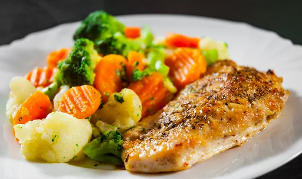 chicken fillet with Mixed vegetables. cauliflower, broccoli and carrots in white plate on a wooden background.