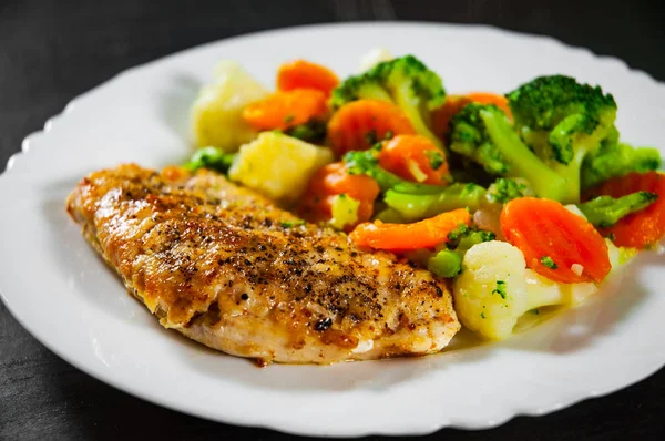 chicken fillet with Mixed vegetables. cauliflower, broccoli and carrots in white plate on a wooden background.
