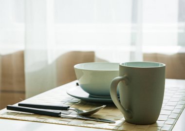 Bardak ve tabak içinde modern yemek odası evde ahşap masa.