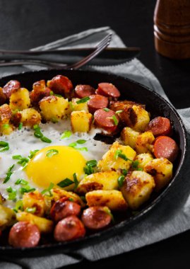 sosis ve patates ahşap masa üzerinde bir tavada kızarmış yumurta