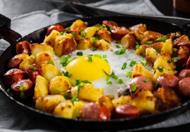 sosis ve patates ahşap masa üzerinde bir tavada kızarmış yumurta